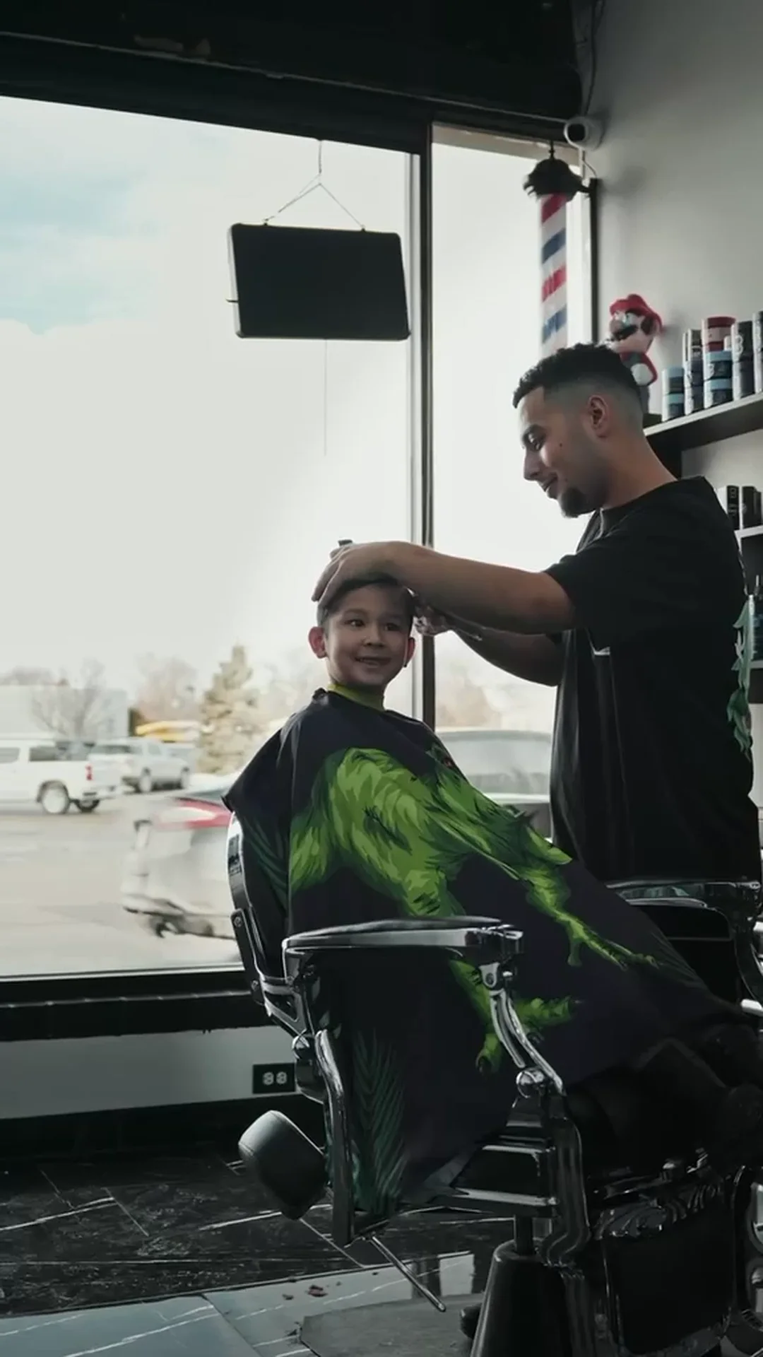 A young client in the chair by the shop window